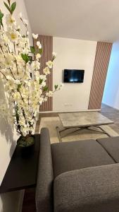 - un salon avec un canapé et un vase de fleurs dans l'établissement Appartement avec terrasse, à Vierzon