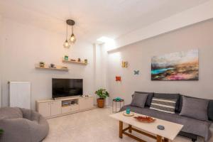sala de estar con sofá y TV en DM-Discover Margarites Home, en Margarítai