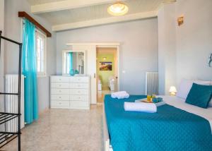 Un dormitorio con una cama azul con toallas. en DM-Discover Margarites Home, en Margarítai