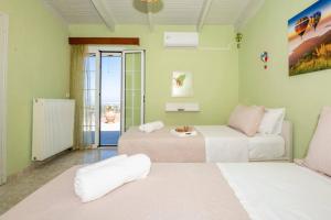 a living room with two beds and a balcony at DM-Discover Margarites Home in Margarítai +38 photos