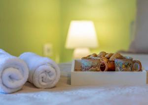 a bed with towels and cups and a box of donuts at DM-Discover Margarites Home in Margarítai