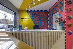 a reception area of a people office with a colorful wall at People Hostel & Coworking in Bishkek