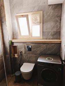 a small bathroom with a toilet and a window at Royal Elegance Room in Sheikh Zayed