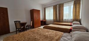 ein Hotelzimmer mit 2 Betten, einem Tisch und Stühlen in der Unterkunft Rest Hostel Airport Modlin in Nowy Dwór Mazowiecki