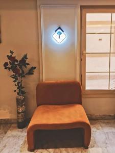 Royal Elegance Room في Sheikh Zayed: كرسي في غرفة مع علامة على الباب