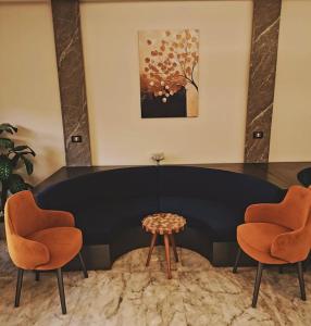 Royal Elegance Room في Sheikh Zayed: قاعة اجتماعات مع كرسيين وطاولة