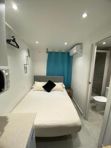 Dormitorio pequeño con cama y aseo en Suites con baño privado frente a la estación de metro L5 Fira Barcelona, en Hospitalet de Llobregat