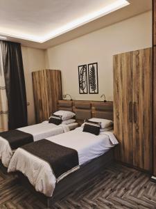 two beds in a room with wooden dividers at Royal Elegance Room in Sheikh Zayed