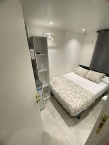 Dormitorio pequeño con cama y armario en Suites con baño privado frente a la estación de metro L5 Fira Barcelona, en Hospitalet de Llobregat