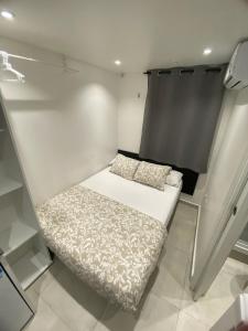 Una cama pequeña en la esquina de una habitación en Suites con baño privado frente a la estación de metro L5 Fira Barcelona, en Hospitalet de Llobregat