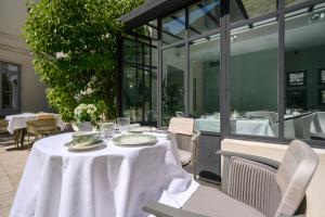 a table with a white table cloth on a patio at Villa Grand Voile - Christopher Coutanceau in La Rochelle