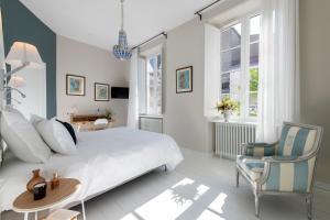 - une chambre avec un lit, une table et une chaise dans l'établissement Villa Grand Voile - Christopher Coutanceau, à La Rochelle