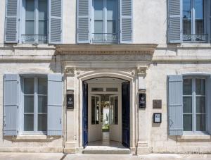 Villa Grand Voile - Christopher Coutanceau في لا روشيل: مدخل لمبنى به مصاريع زرقاء