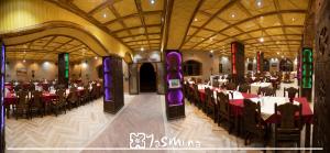 a banquet hall with tables and chairs in a building at Kasbah Yasmina Hotel in Lac Yasmins
