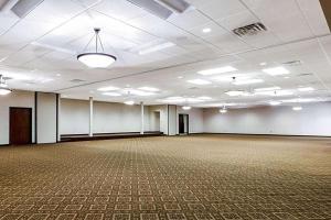 um quarto vazio com um grande salão de baile com paredes brancas em Baymont by Wyndham Jamestown Conference Center & Water Park em Jamestown