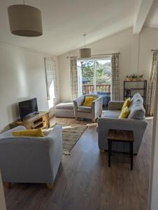 a living room with two couches and a tv at Two Bedroom Lodge In The Country - Oak, Stag, Acorn in Liskeard