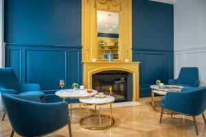 a living room with blue walls and a fireplace at Villa Grand Voile - Christopher Coutanceau in La Rochelle