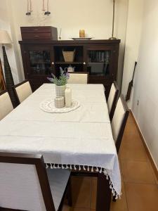 tavolo da pranzo con una tovaglia bianca e una candela di Chalet La Calma en Lorca a Lorca