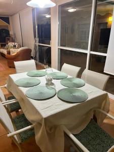 una mesa con cuatro platos verdes encima en Chalet La Calma en Lorca, en Lorca
