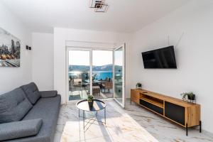 een woonkamer met een bank en een tv bij La Vie luxury apartments with a pool in Stara Novalja