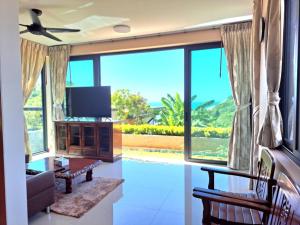 a living room with a tv and a large window at Seaview Eagles Nest Apartment 2 in Rawai Beach