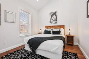 a bedroom with a large bed with a black and white blanket at Adorable Reymer Carriage Repair Loft! in Pittsburgh
