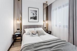 una camera con un grande letto e due comodini di Rent like home - Apartamenty DEO PLAZA a Danzica