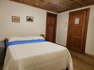 1 dormitorio con 1 cama grande y puerta de madera en Grand Hotel Ceresole Reale studio apartment, en Ceresole Reale