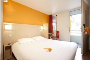 a hotel room with a large white bed and a window at Premiere Classe Vichy - Bellerive Sur Allier in Bellerive-sur-Allier