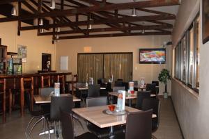 um restaurante com mesas e cadeiras e um bar em Travel Lodge em Middelburg