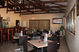 un ristorante con tavoli e sedie e un bar di Travel Lodge a Middelburg