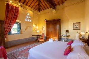 1 dormitorio con cama blanca y escritorio en Cortona Resort-Le Terre Dei Cavalieri en Cortona