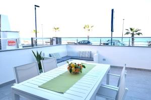 a table with a bowl of fruit on a balcony at Thetis Apartments in Furci Siculo