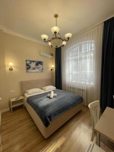 een slaapkamer met een bed en een kroonluchter bij Rose Art hotel in Astana