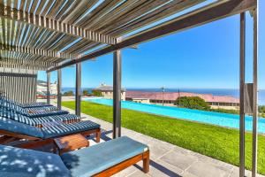 un patio con sedie a sdraio e una piscina di The Crystal Apartments a Città del Capo