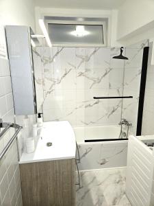 a white bathroom with a sink and a shower at Studio entre plages et Monaco climatisé parking in Roquebrune-Cap-Martin