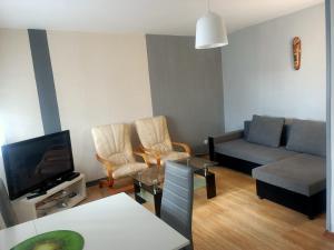 a living room with a couch and a tv at Apartament u Anny in Szczytna