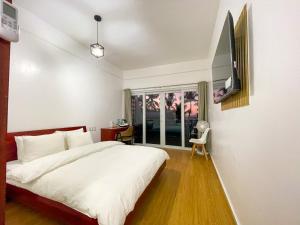 sypialnia z łóżkiem i telewizorem na ścianie w obiekcie Montani Beach Resort Puerto Galera powered by Cocotel w mieście Puerto Galera