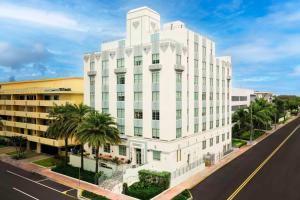 Hilton Garden Inn Miami South Beach في ميامي بيتش: عمارة بيضاء فيها نخل قدام شارع
