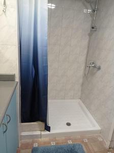 a shower with a blue shower curtain in a bathroom at הפינה היפה ליד החומות in Jerusalem