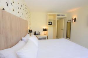 - une chambre avec un grand lit blanc et des oreillers blancs dans l'établissement Best Western Gemenos en Provence, à Gémenos