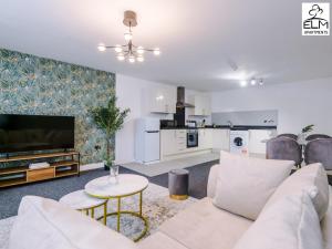 a living room with a white couch and a tv at Elm Aparthotel , Collection of apartments Available Near Media City , Free Parking in Manchester