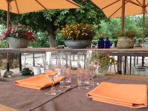 una mesa con copas de vino y servilletas naranjas. en Les Deux Ponts, en Pierre-Perthuis