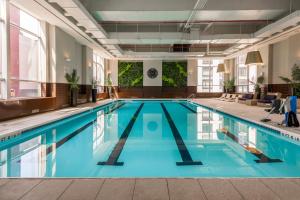 a swimming pool with blue water in a building at Blueground Midtown West gym wd nr museum NYC-1452 in New York