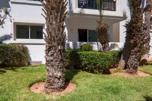 um grupo de palmeiras em frente a uma casa em Blue Note - Marina Agadir - Piscine - 4 or 5 Px em Agadir