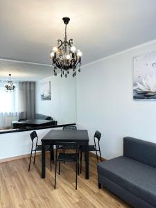 a dining room with a table and a couch at Coser Apartamenty ONZ in Warsaw