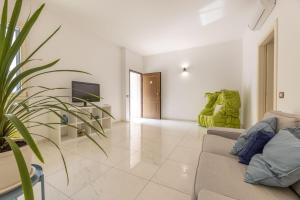 een woonkamer met een bank en een tv bij Quadrilocale Corso Italia 29 piano terra con spazio esterno in Gallipoli