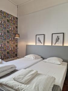 dwa łóżka w pokoju z trzema zdjęciami na ścianie w obiekcie Castilho 63 Hostel & Suites w Lizbonie