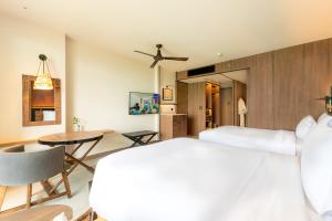 een slaapkamer met een bed en een eetkamer bij Centara Grand Mirage Beach Resort Pattaya in Noord Pattaya