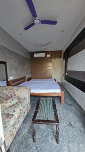 1 dormitorio con cama, sofá y ventilador de techo en MR.WHITE PRIME RESIDENCY en Chennai